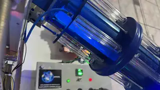 Câmara de confinamento vista de outro ângulo, com bobinas de excitação ao redor do tubo de vidro