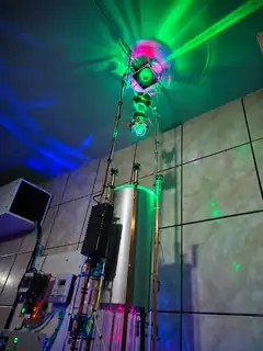 O feixe verde irradiando do emissor superior, visto de baixo do sistema de emissão óptica